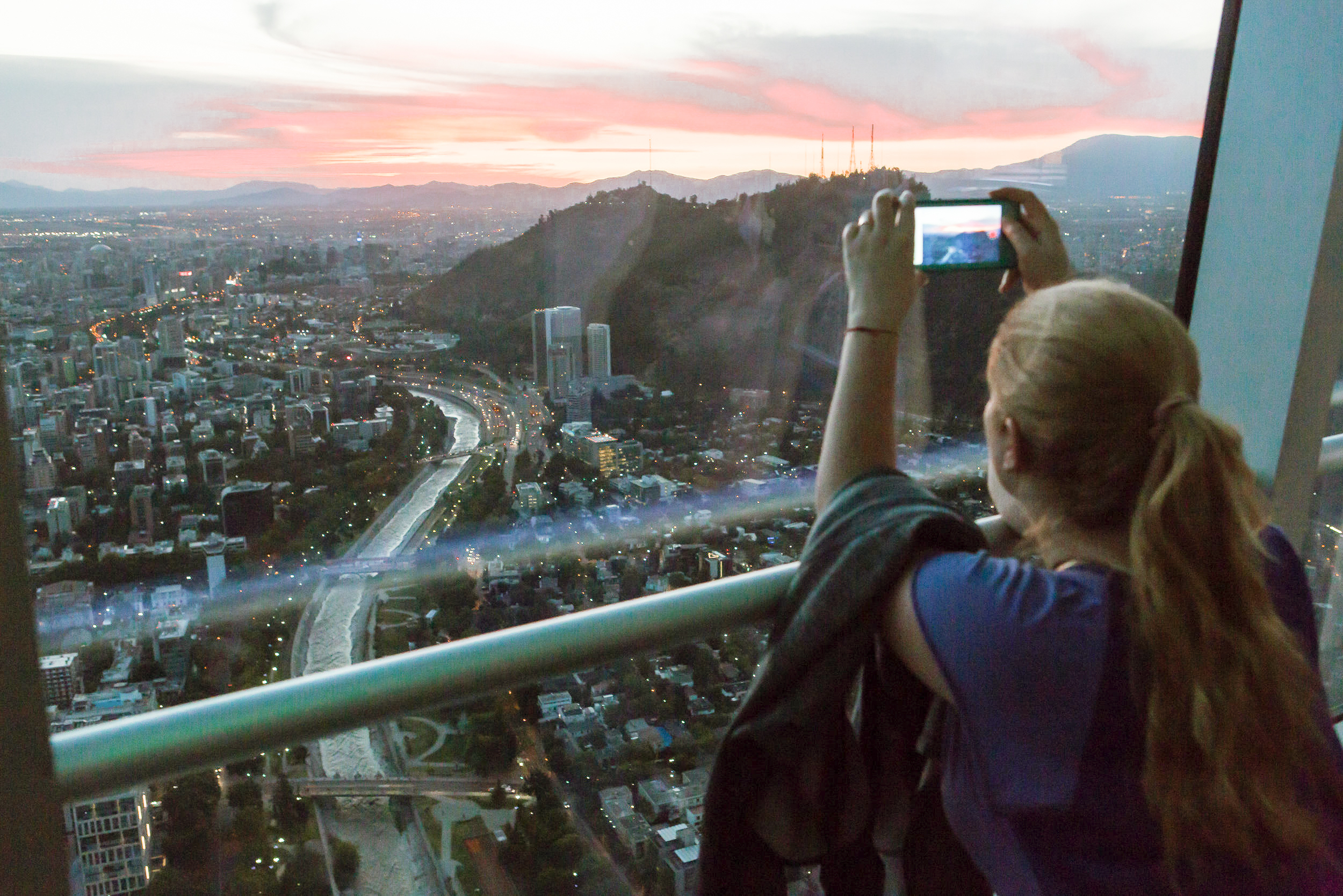 una persona en Sky Costanera tomando una foto del atardecer